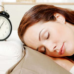 Woman sleeping beside an alarm clock