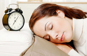 Woman sleeping beside an alarm clock