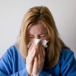 woman sneezing because of allergy